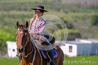 CAMINOS, CANELONES, URUGUAY, OCT 7, 2018: Female gaucho riding on a horse at a Criolla Festival in Uruguay Editorial Stock Photo
