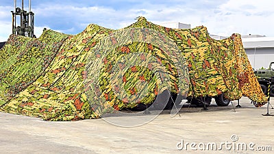 Camouflage awning for shelter of military equipment Stock Photo