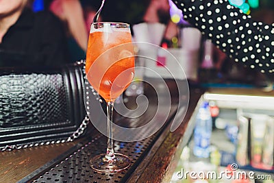 Campari tonic alcoholic cocktail with red bitter, tonic, lime and ice. Old wooden table background, bar tools, selective Stock Photo