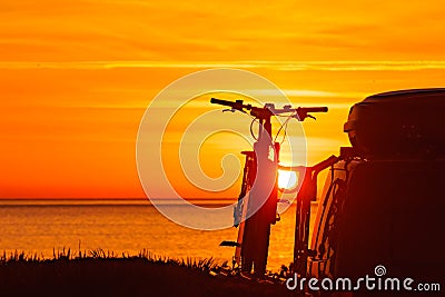 Camper with bicycles on rack camping on beach at sunrise Stock Photo