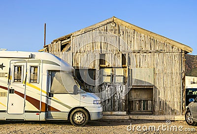 Camper parked in front of a wooden cabin Editorial Stock Photo