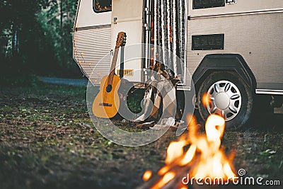 Camper van with gitar and fire place parking in forest at night Stock Photo