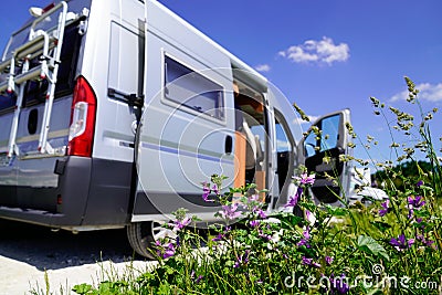 Camper van during vacation travel in RV holiday trip in motorhome with spring flowers Stock Photo