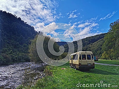 Campervan parked near river on regional park in New Zealand Editorial Stock Photo