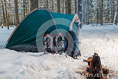 A campfire near a tent in a winter camping Stock Photo