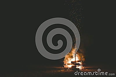 Campfire with sparks flying around in the dark night Stock Photo