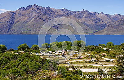 Campground by mountains and blue lake Stock Photo