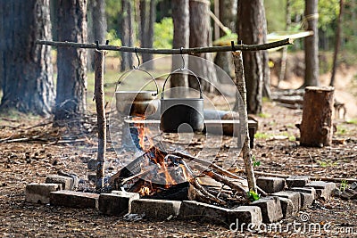 Camping cooking with homemade tools and kettles. Stock Photo