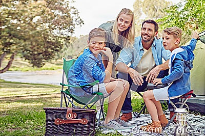 Camping is a family pasttime. a family of four camping in the woods. Stock Photo
