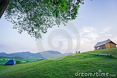 Camping and tent on Lawn or green grass ground in morning, vacation picnic on holiday relax, Camping season, sky and mountains Editorial Stock Photo