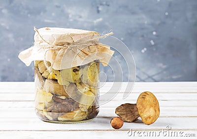 A can of canned mushrooms on a white wooden table on a gray blurry background. Aspen, boletus Stock Photo