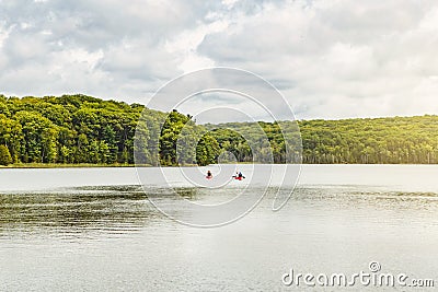 Canada forest park nature with family friends riding in red kayaks canoe boats in water. Editorial Stock Photo