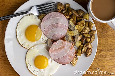 canadian bacon with fried eggs and home fries Stock Photo