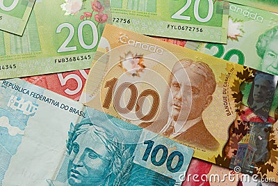 Canadian Dollars and Brazilian currency. Full frame of bills spread on table and assorted amounts. Editorial Stock Photo