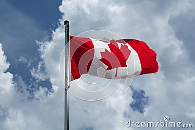 Canadian Flag flies proudly against a blue cloudy sky Stock Photo