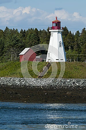 Canadian Lighthouse On Rocky Coast During Low Tide Stock Photo