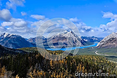 Canadian Rockies landscape with lakes and mountains covered with snow and golden larches in autumn. Stock Photo