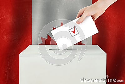 Canadian Vote concept. Voter hand holding ballot paper for election vote on polling station Stock Photo