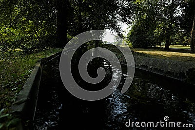 Canal in a park with fluent water Stock Photo