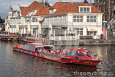 Canal tour boat giving tourist rides. Urban landscape and historic building Editorial Stock Photo