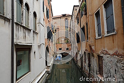 Canal in Venice with docked gondola and boats, Stock Photo