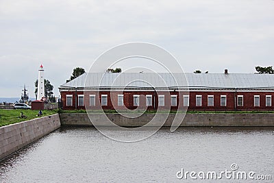 A canal with water for seaworthy ships calling. Stone historical ancient walls with metal rings for mooring. The building of the d Editorial Stock Photo