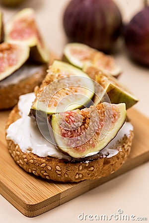 Canape or Crostini with Toasted Baguette Cream Cheese and Figs on Wooden Board Delicious Appetizer Lunch Yellow Background Close Stock Photo