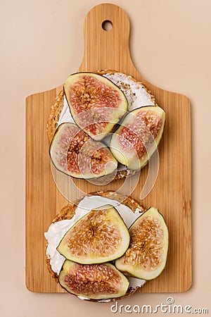 Canape or Crostini with Toasted Baguette Cream Cheese and Figs on Wooden Board Delicious Appetizer Lunch Yellow Background Top Stock Photo