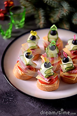 CanapÃ© on skewer from bread baguette with toast cheese, sausage, tomato, cucumber and olives. Traditional snack for the New Year. Stock Photo