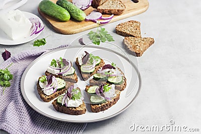 CanapÃ©s with toasted bread with sunflower and flax seeds, feta cheese, cucumber and onion Stock Photo