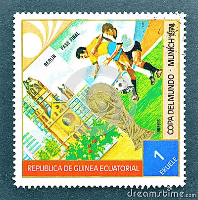 Cancelled postage stamp printed by Guinea Equatorial, that shows Football players, World cup trophy and Berlin Editorial Stock Photo