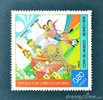 Cancelled postage stamp printed by Guinea Equatorial, that shows Football players, World cup trophy and Stuttgart Editorial Stock Photo