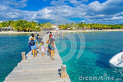 CANCUN, MEXICO - JANUARY 10, 2018: Beautiful outdoor view of unidentified tourist walking over a wooden pier in the Isla Editorial Stock Photo
