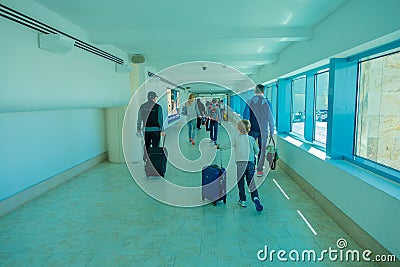 CANCUN, MEXICO - JANUARY 10, 2018: Unidentified people walking carrying their luggages in a hall inside of the Cancun Editorial Stock Photo
