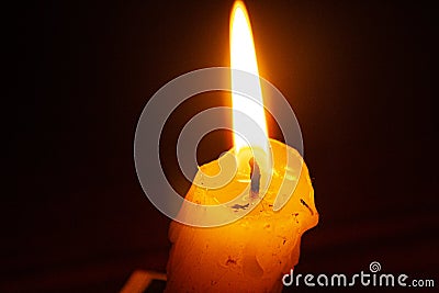 candel with black backround and a fire. Burning candle in the dark on the table close up top view. Flame of a burning candle close Stock Photo