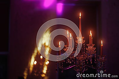 Candelabra with candles in purple backlit background Stock Photo
