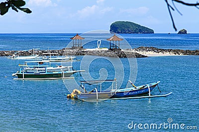Candi Dasa beach with traditional outrigger fishing boats in Bali, Indonesia. Editorial Stock Photo
