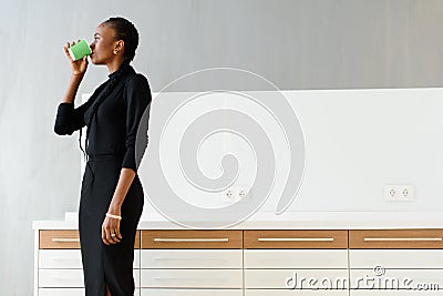 Candid image of a businesswoman drinking coffee while working at light office Stock Photo