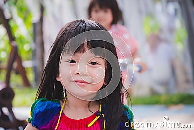 Candid image child 3-4 years old. Face sweet smile little girl in park playground. Head shot happy adorable kid Summer or spring Stock Photo