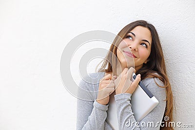 Candid innocent teenager girl cuddling a tablet and looking above Stock Photo