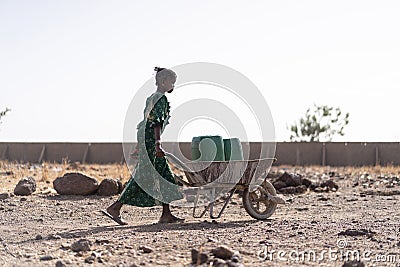 Candid photo of West Africa Women getting Tap Water in an arid zone Stock Photo