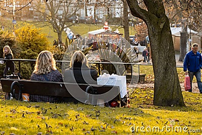 Two Women Relaxing on a Park Seat. Editorial Stock Photo