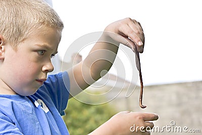 Candid portrait of boy playing with a worm Stock Photo