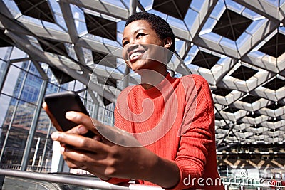 Candid portrait of smiling african american woman holding phone Stock Photo