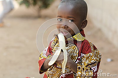 Candid Shot of African Black Boy Eating Banana Outdoor Stock Photo