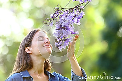 Candid woman smelling flowers in a park Stock Photo