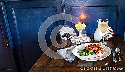 Candied bacon wrapped sea scallops over a bed of asparagus on fine China Stock Photo