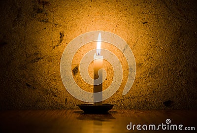 Candle burning, grungy wall background Stock Photo