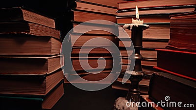 Candle in candlestick with old books, slider footage in antique shop, bookstore. Stock Photo