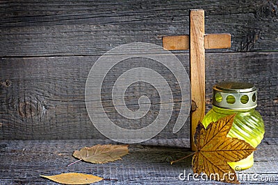 Candle and cemetery cross on wooden background in autumn Stock Photo